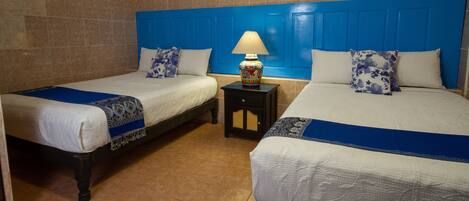 A hotel room with two beds, a nightstand, and a wall painting.
