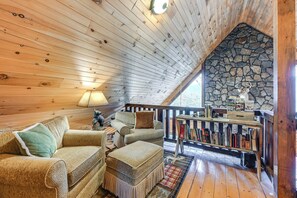 Relax in a cozy cabin-style room with a seating area, wooden table, and stone wall.