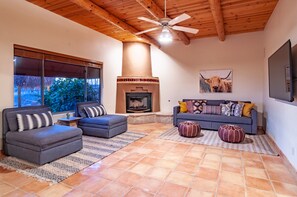 Relax in this inviting living room with a fireplace, large window, and flat-screen TV.