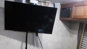 Een flatscreen televisie bevestigd aan een muur, aangesloten op een stekkerdoos.