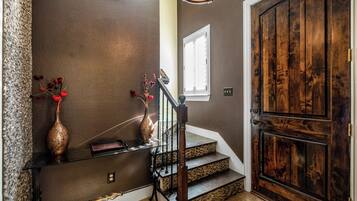 Un escalier avec une porte en bois, un vase et une fenêtre.