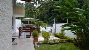 A patio area with a dining set, potted plants, and a white fence. - A house with views in Caracas in a safe area I (Caracas)