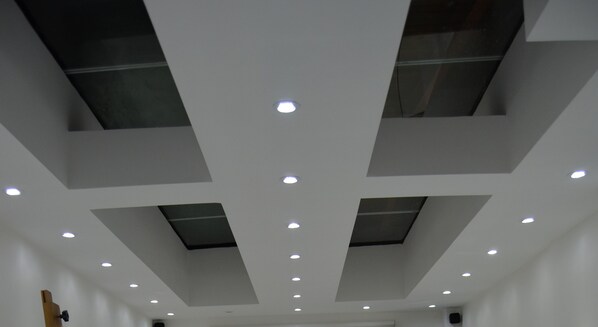 A ceiling with recessed lighting and skylights.