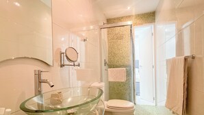 A modern bathroom with a glass sink, a toilet, and a shower area. - A house with views in Caracas in a safe area I (Caracas)