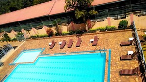 Piscina con sillas de descanso y zona cubierta.