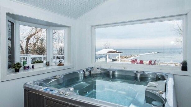 A hot tub with a view of the ocean and beach.