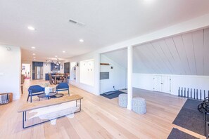 A spacious living area with a wooden floor, a dining table, and blue chairs. - Prospector 836 (Park City)