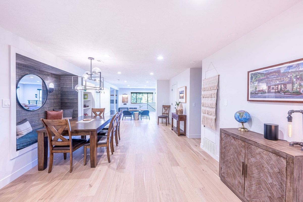 Una cocina moderna con comedor, armarios de madera y vistas al salón.