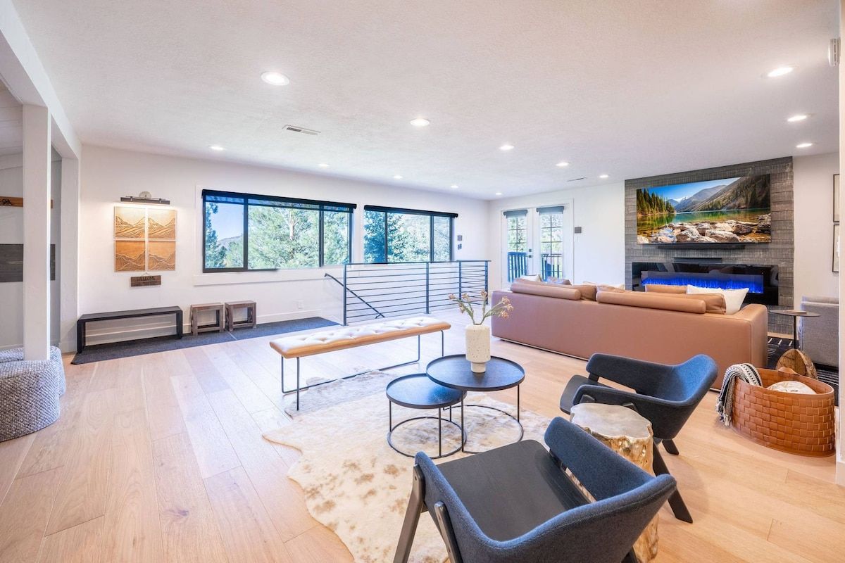 A modern living room with a sofa, chairs, a coffee table, and a fireplace.