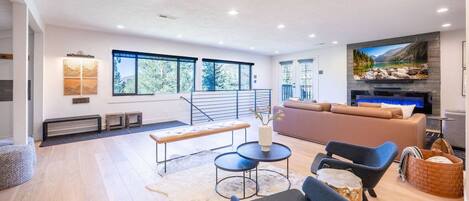 A modern living room with a sofa, chairs, a coffee table, and a fireplace.