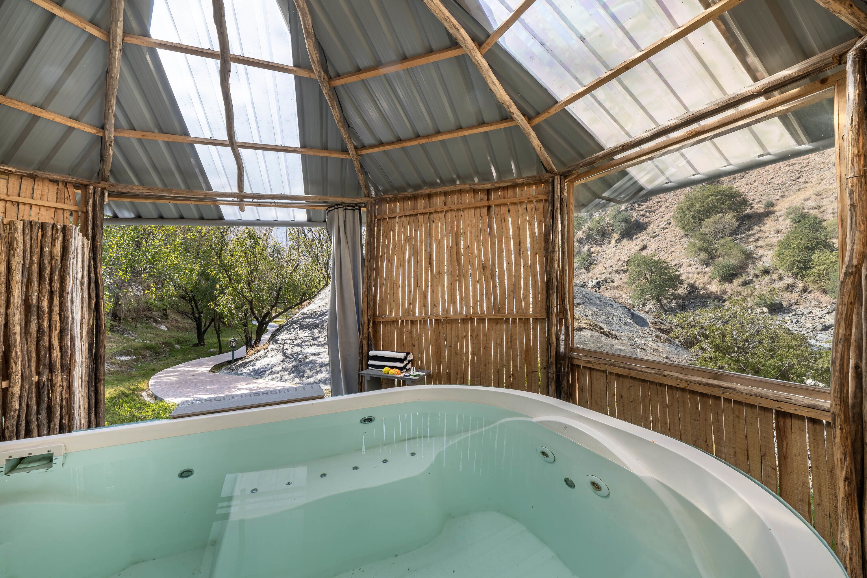A hot tub with a wooden frame and a view of a hilly landscape.