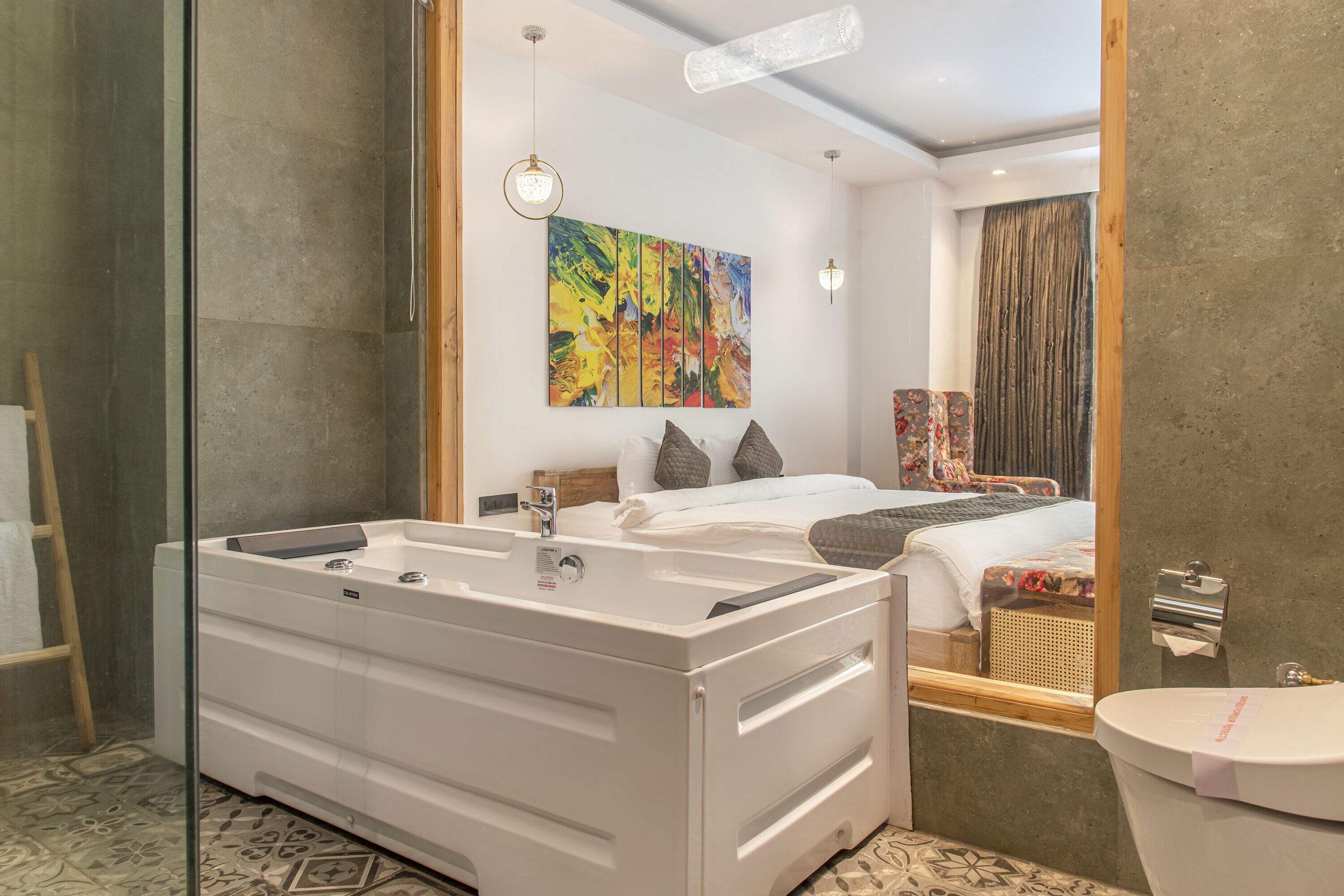 A modern bathroom with a large bathtub, a separate sink, and a toilet.