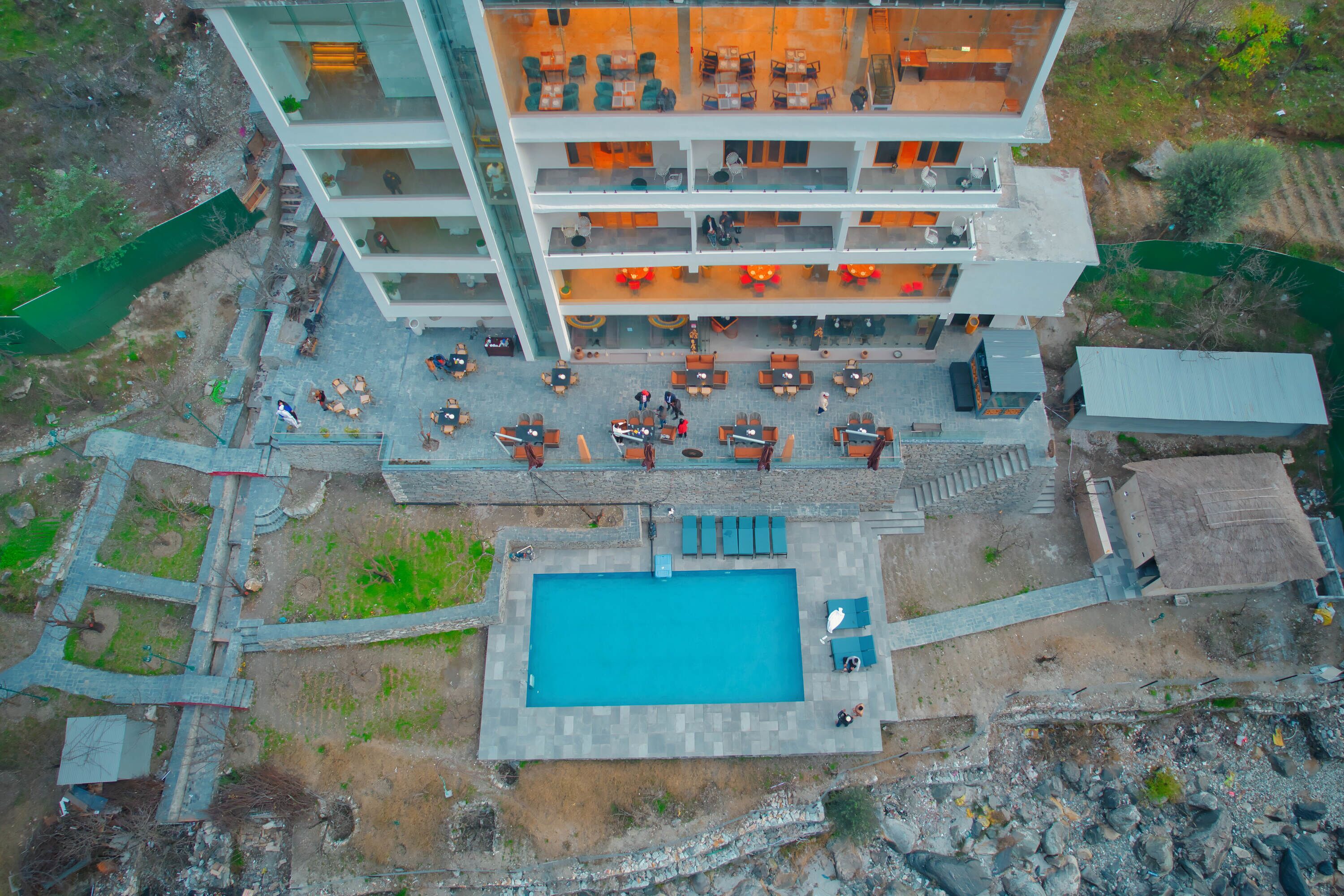 A multi-story hotel with a rooftop pool and outdoor seating area.