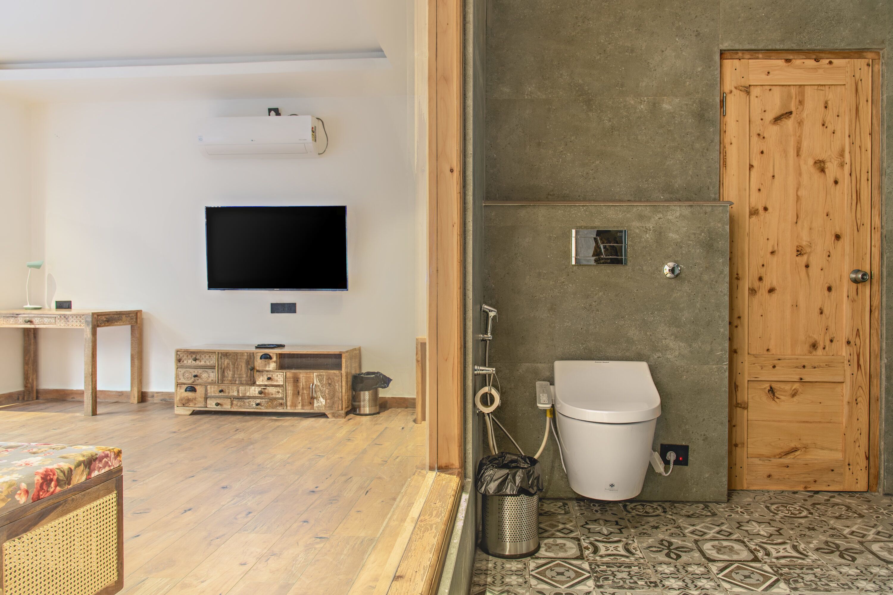 A bathroom with a toilet, shower, and a wooden door.