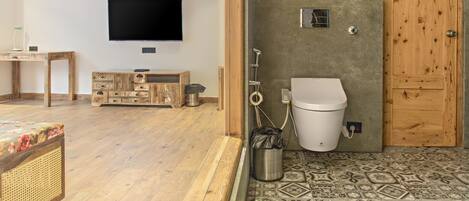 A bathroom with a toilet, shower, and a wooden door.