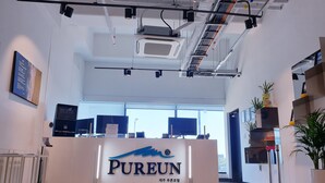 Uma área de recepção com uma placa indicando "PUREUN" e design de interiores moderno.