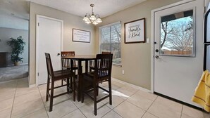 A dining area with a table and chairs, a ceiling light, and two framed quotes on the wall. - Modern Pflugerville Home Near Austin and Tech Hub (Pflugerville)