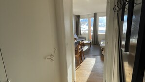 Ein Flur, der in einen Essbereich mit Holzboden und Blick auf Berge durch ein Fenster führt.