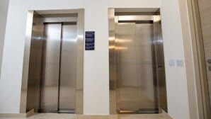 Dos puertas de ascensor con un cartel arriba.