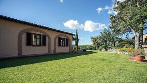 A house with a well-maintained lawn and a clear blue sky.
