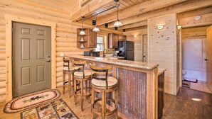 Ein Holzhütten-Interieur mit Barbereich, Küche und einer Tür.