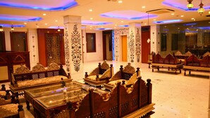 A luxurious hotel lobby with ornate furniture, decorative columns, and a modern ceiling design. - The Heritage Palace (Jaipur)