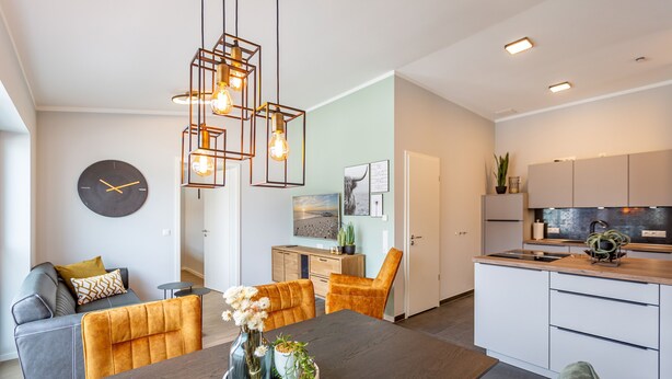 A modern kitchen with white cabinets, a wooden countertop, and a built-in oven. - Quartier Frohsinn, app. 11 (Heringsdorf)