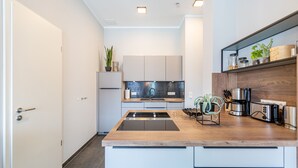 A modern kitchen with a central island, built-in appliances, and a wooden countertop. - Quartier Frohsinn, app. 11 (Heringsdorf)