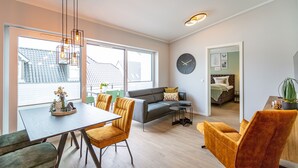 A modern living space with a dining area, sofa, and a view of the outside. - Quartier Frohsinn, app. 11 (Heringsdorf)
