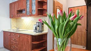 Een keuken met houten kastjes, een koffiezetapparaat en een vaas met tulpen op een houten tafel.