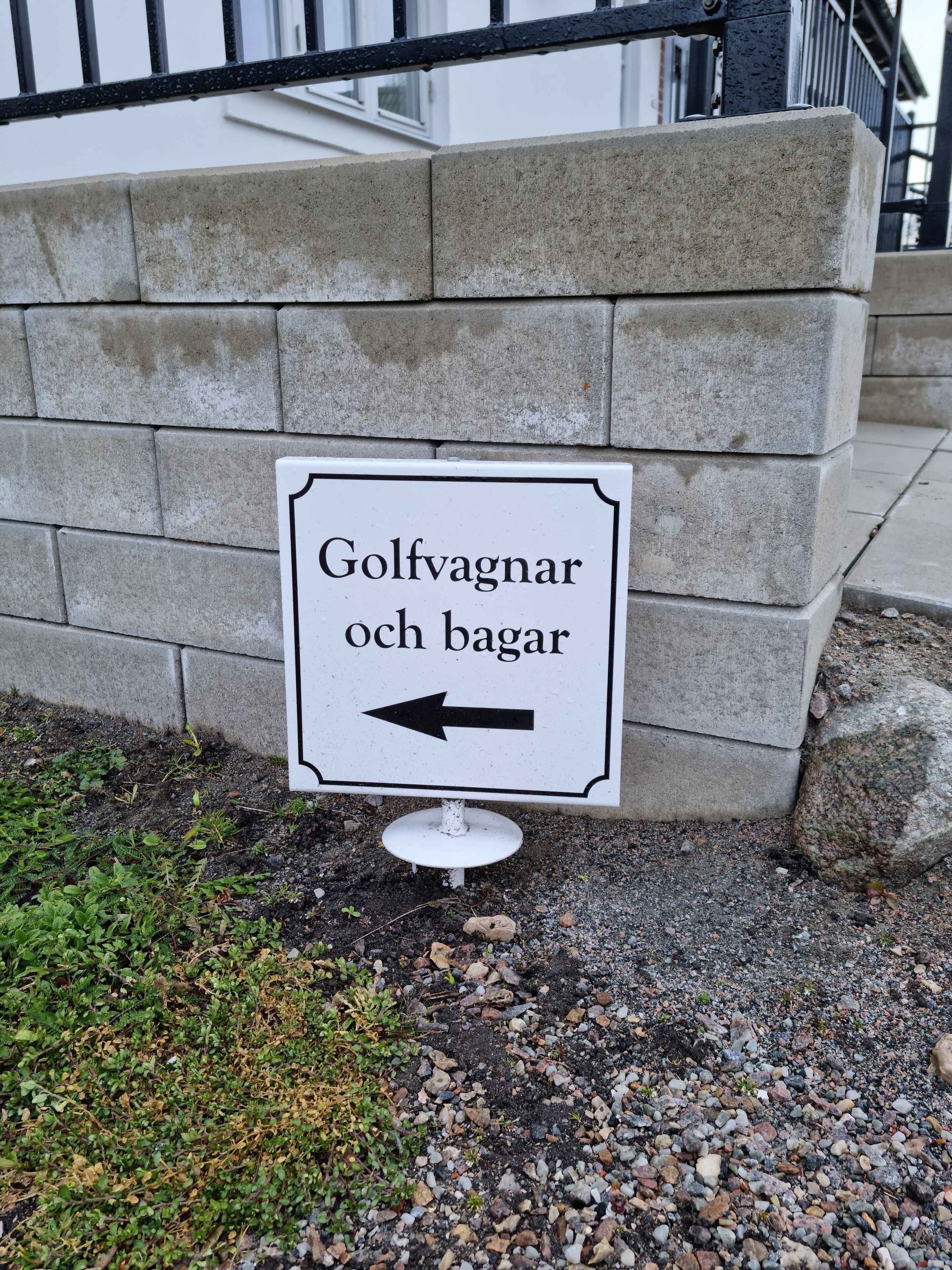 A directional sign for a golf course and parking area.