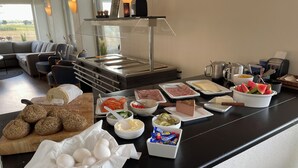 Un buffet con diversi alimenti, tra cui pane, uova, verdure e carni.