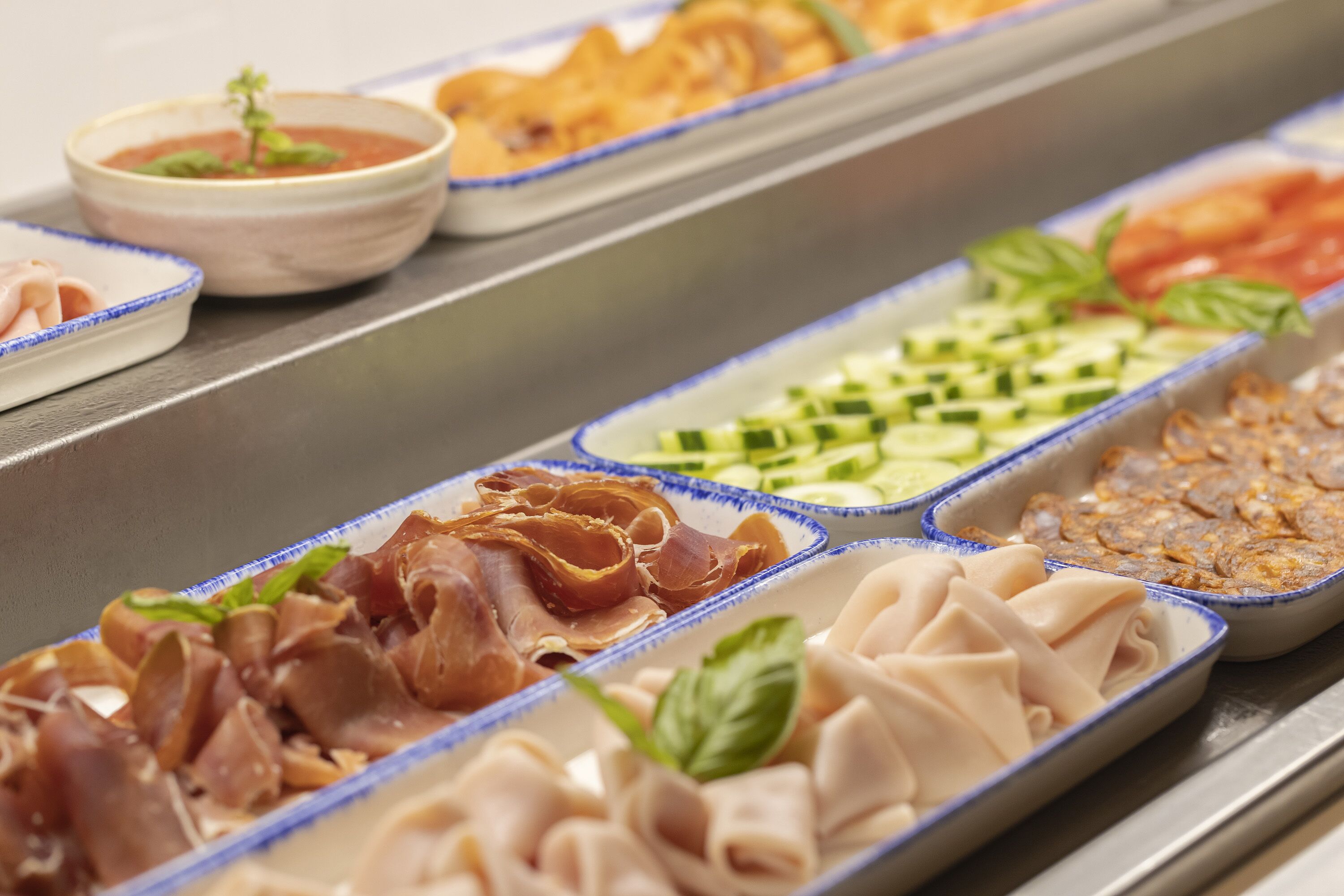 Un buffet proposant une variété de plats, notamment des viandes, des légumes et des sauces.