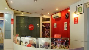 A reception area with a red wall, a 'Q' logo, and a 'No Smoking' sign. - OYO Rooms Inside Udaipole (Udaipur)