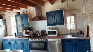 A kitchen with blue cabinets, a stainless steel stove, a microwave, and a dishwasher. - Comfortable house with swimming pool in season for 8 people close to all amenities (Amboise)