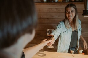 A wooden table with a bottle and a glass, suggesting a bar or dining area.