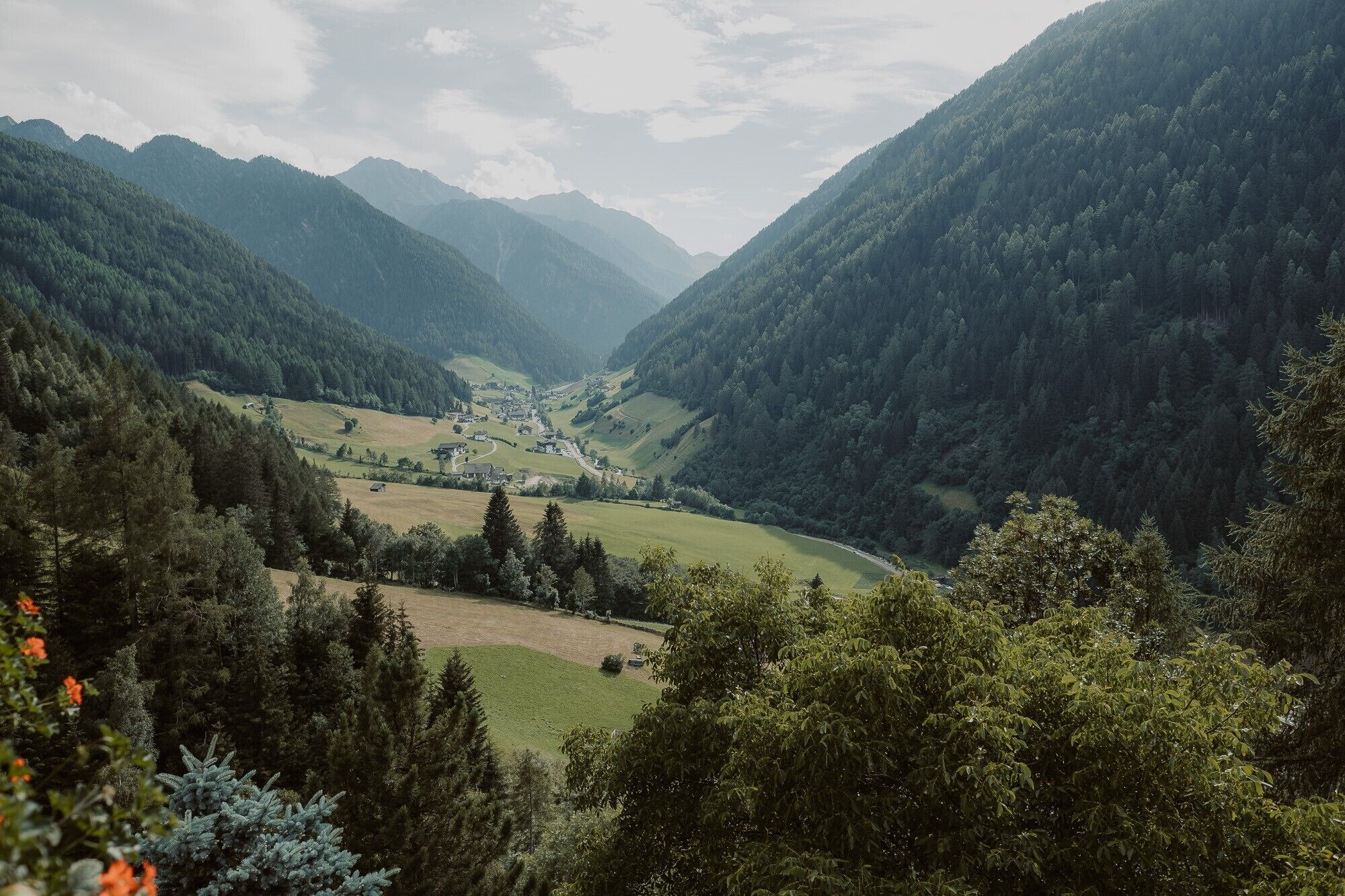 Une vallée abritant un petit village, entourée de montagnes.