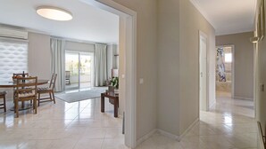 A spacious living area with a dining table, chairs, and a view to a balcony. - 'Vilamoura Apartment 3 bedroom' with Sea View, Terraces, Shared Pool & Wi-Fi (Vilamoura)