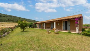 Un bâtiment d’un seul étage, doté d’un toit plat, d’une terrasse avec deux chaises et d’une petite table.