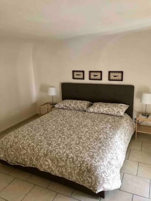 Ein Schlafzimmer mit einem Bett, zwei Nachttischen und drei Wanduhren.