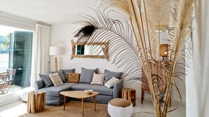 A living room with a sofa, coffee table, and decorative plants.