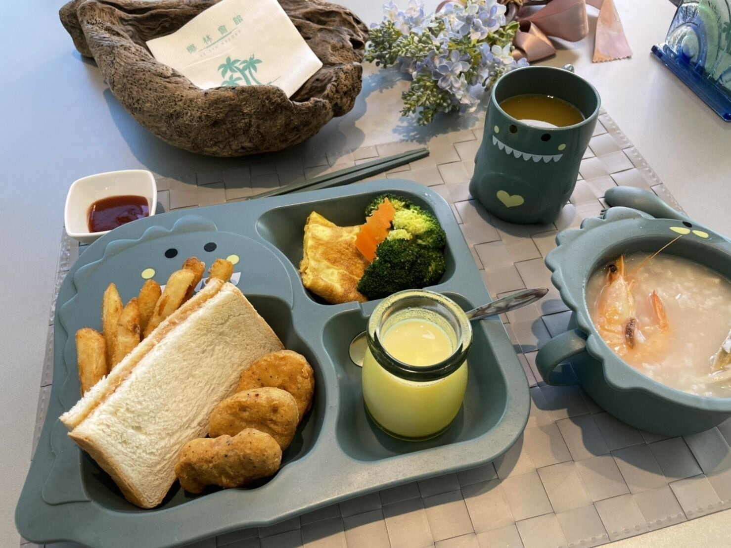 Una bandeja de comida con alimentos fritos, pan, brócoli y sopa.