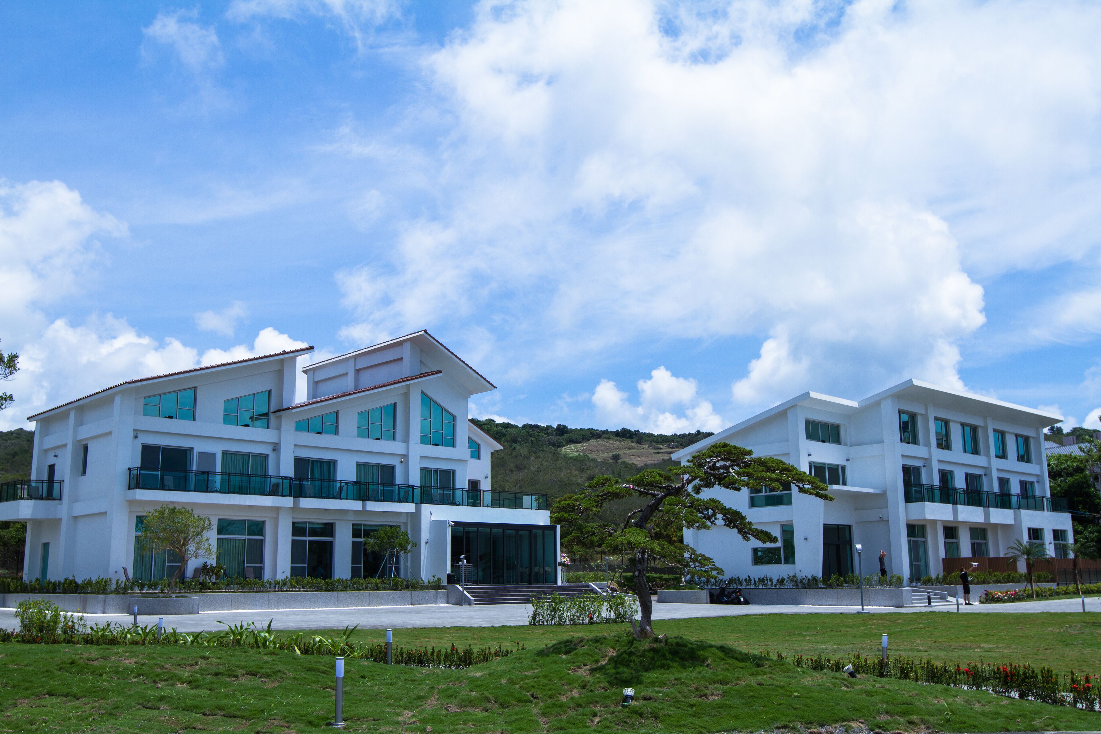 A modern two-story building with large windows and a flat roof.