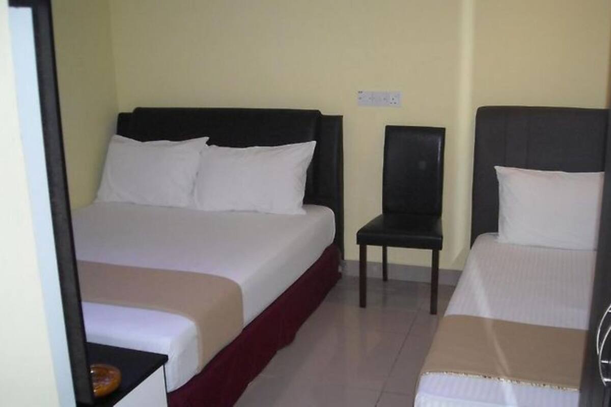 A hotel room with a bed, a chair, and a small table.