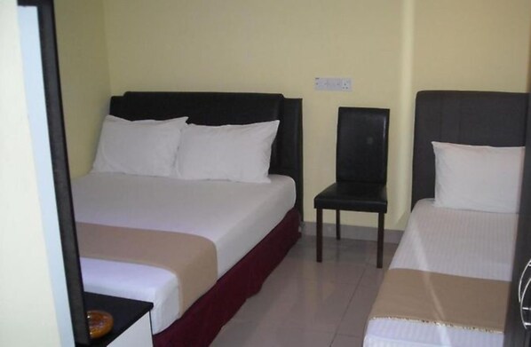 A hotel room with a bed, a chair, and a small table. - OYO 90461 Melawati Times Inn (Taman Melawati)