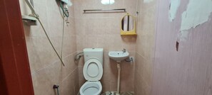 A bathroom with a toilet, sink, and a mirror. - OYO 90461 Melawati Times Inn (Taman Melawati)