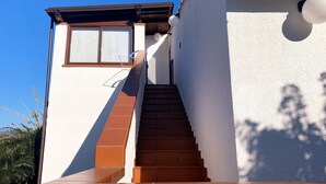 A staircase leading to a white building with a brown roof and a window. - BlueMoon Home (Campofelice di Roccella)