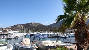 A marina with several boats docked, surrounded by greenery and a mountainous backdrop. - Nice 2-room Apt, 4 people, Lumio, AC, parking (Lumio)
