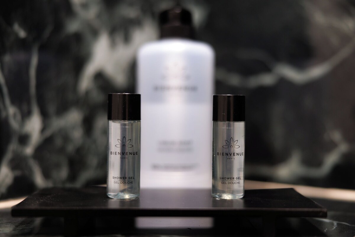 Three bottles of shower gel on a black surface with a blurred background.