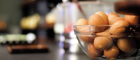 A clear glass bowl filled with eggs on a kitchen counter.